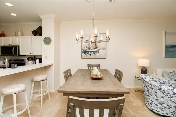 a kitchen with kitchen island stainless steel appliances a dining table and chairs