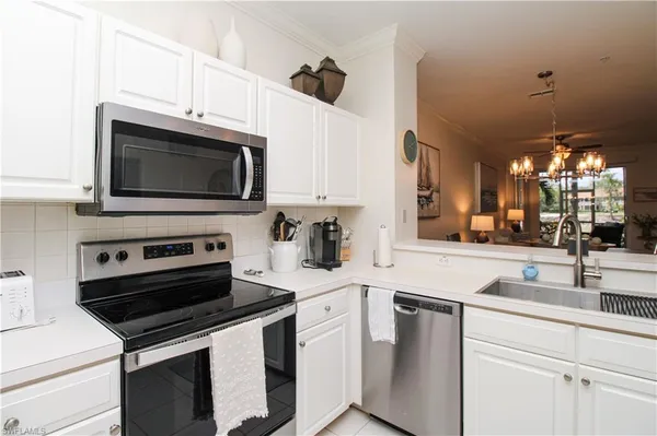 a kitchen with stainless steel appliances a stove microwave and sink