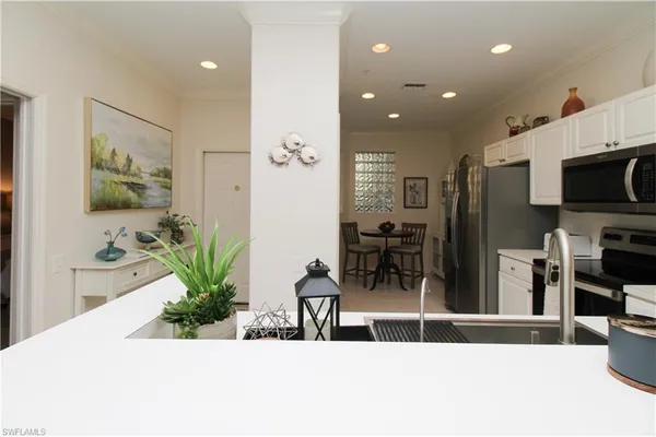 a living room with stainless steel appliances kitchen island granite countertop furniture a flat screen tv and a faucet