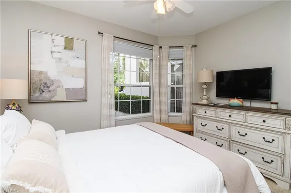 a bedroom with a large bed and a flat screen tv