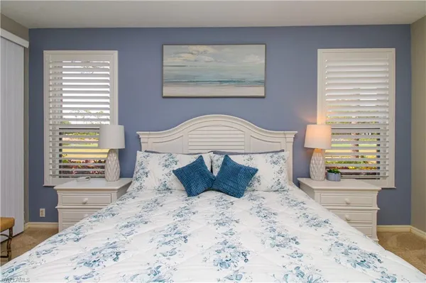 a large bed sitting in a bedroom next to a window