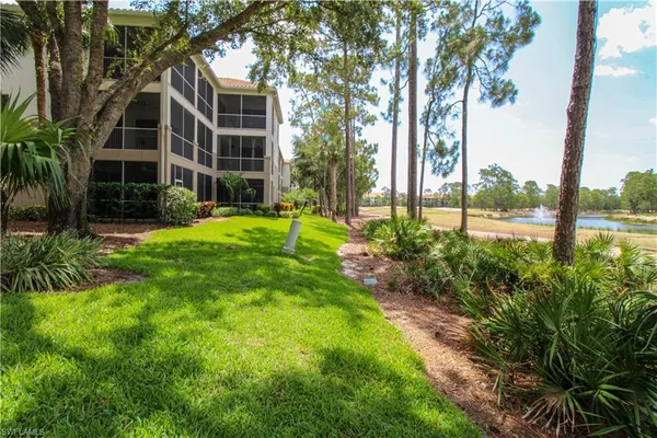 a view of a brick house with a yard and potted plants
