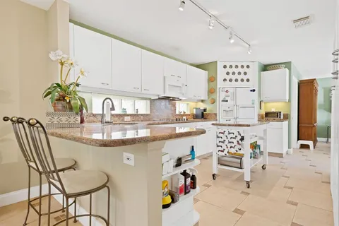a kitchen with stainless steel appliances granite countertop a sink and a refrigerator