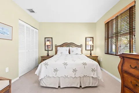 a bedroom with a bed and large windows