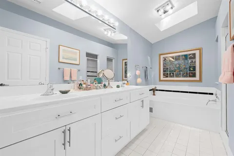 a bathroom with a double vanity sink a mirror and a bathtub