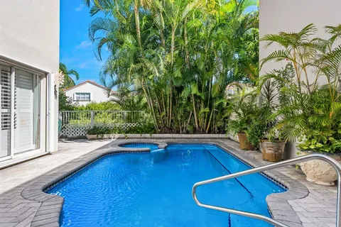 a view of swimming pool on a sunny day with lawn chairs