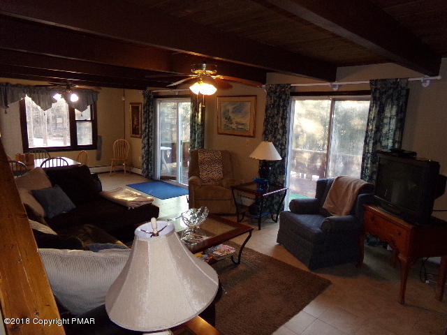 4152 Winchester Way Bushkill, PA 18324 - Photo 11 of 23 a living room with furniture a lamp and a floor to ceiling window