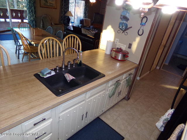 4152 Winchester Way Bushkill, PA 18324 - Photo 9 of 23 a kitchen with stainless steel appliances granite countertop a table chairs and a wooden floor