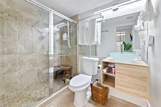 a bathroom with a sink toilet vanity and shower