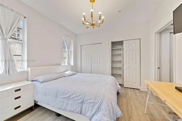 a bedroom with a bed and a chandelier