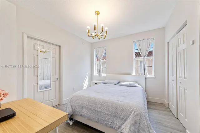 a bedroom with a bed and a chandelier