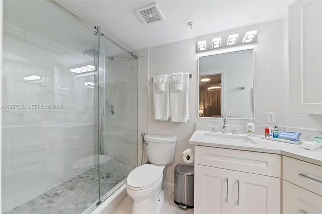 a bathroom with a sink toilet a mirror and shower