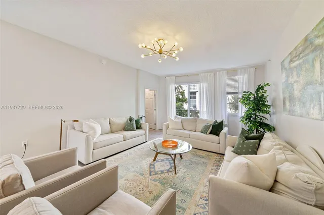 a living room with furniture and a chandelier