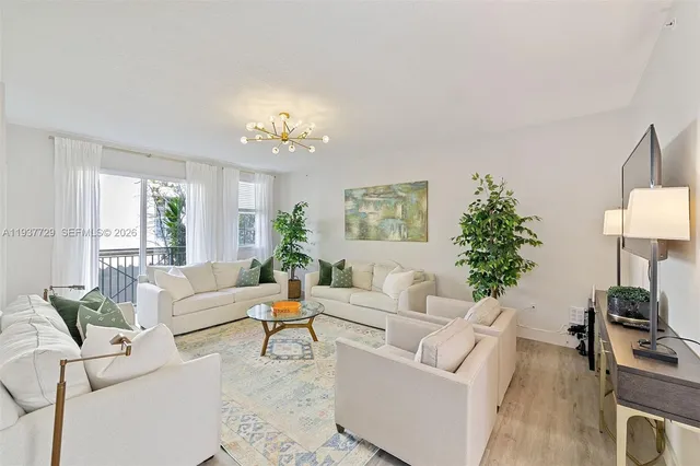 a living room with furniture a lamp and a potted plant