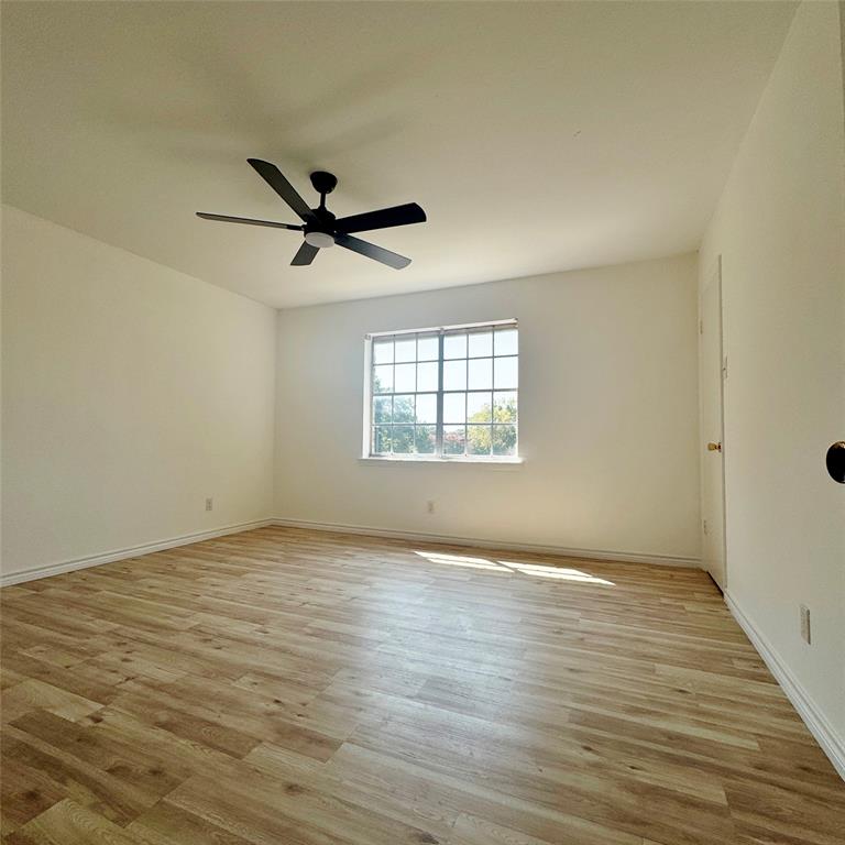 1809 East Grauwyler Road, Unit 133 Irving, TX 75061 - Photo 11 of 18 an empty room with wooden floor and windows