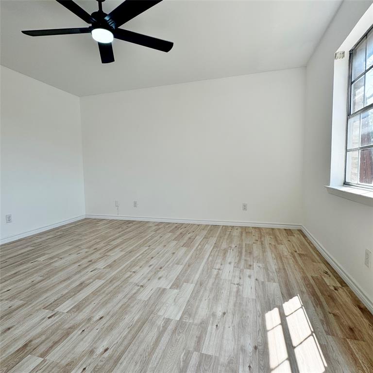 1809 East Grauwyler Road, Unit 133 Irving, TX 75061 - Photo 12 of 18 an empty room with wooden floor fan and windows