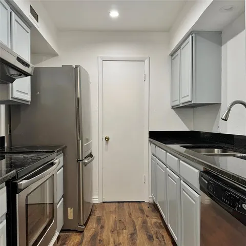 a kitchen with granite countertop a stove and a refrigerator