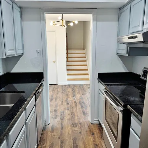 a kitchen with granite countertop a stove and a sink
