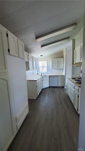 a kitchen with cabinets and wooden floor