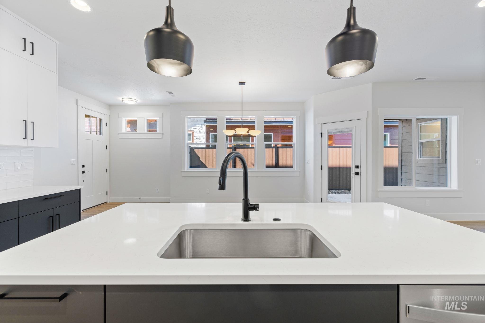 22 Bridger Street Cascade, ID 83611 - Photo 14 of 39 Kitchen featuring pendant lighting, recessed lighting, light stone countertops, light wood-style floors, and white cabinetry