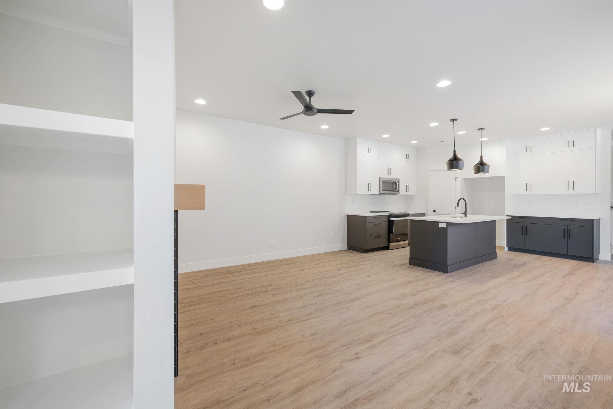 22 Bridger Street Cascade, ID 83611 - Photo 18 of 39 Kitchen with light wood-type flooring, white cabinetry, recessed lighting, a center island with sink, and decorative light fixtures