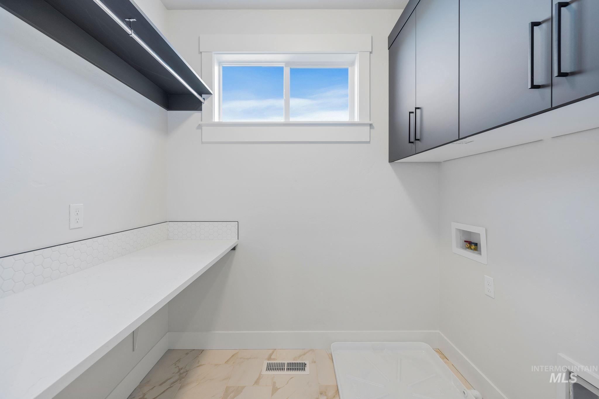 22 Bridger Street Cascade, ID 83611 - Photo 26 of 39 Washroom with washer hookup, light marble finish flooring, and cabinet space