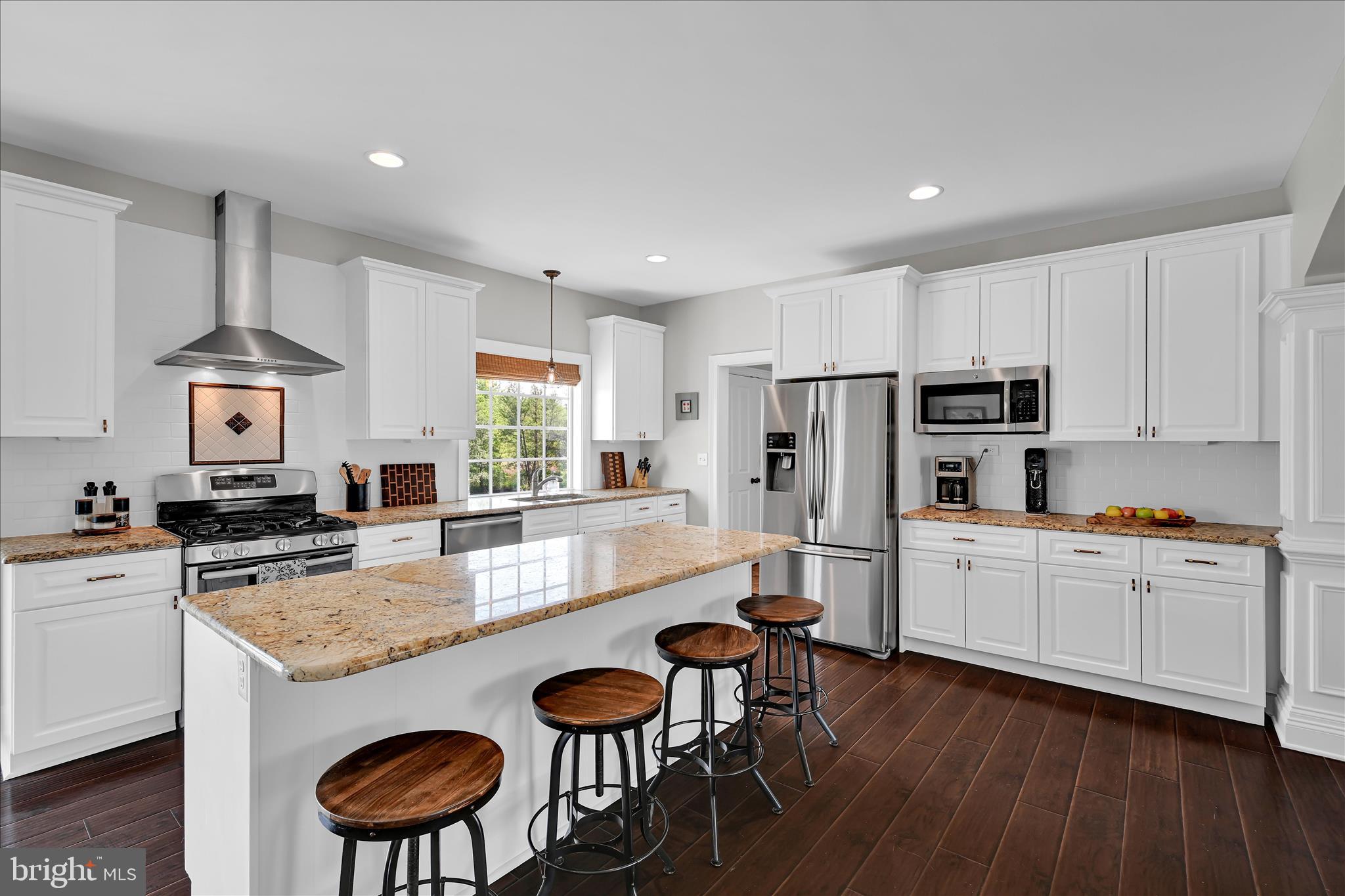 678 Integrity Drive Lititz, PA 17543 - Photo 7 of 51 a kitchen with stainless steel appliances granite countertop a stove top oven a refrigerator a sink and a dining table with wooden floor