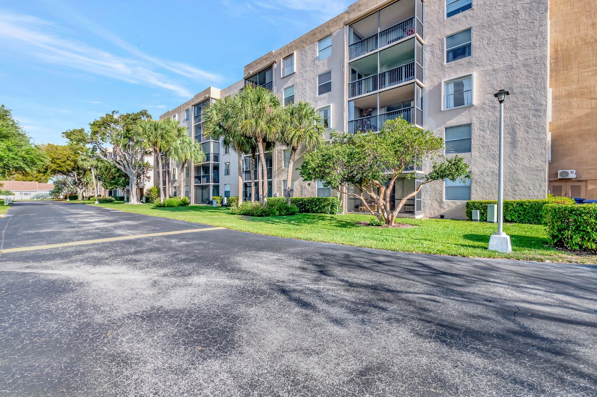 5260 Northwest 2nd Avenue, Unit 307 Boca Raton, FL 33487 - Photo 2 of 16 a front view of a building with garden