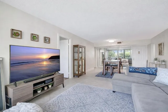 a kitchen with stainless steel appliances granite countertop a stove a microwave a sink a refrigerator white cabinets and a dining table