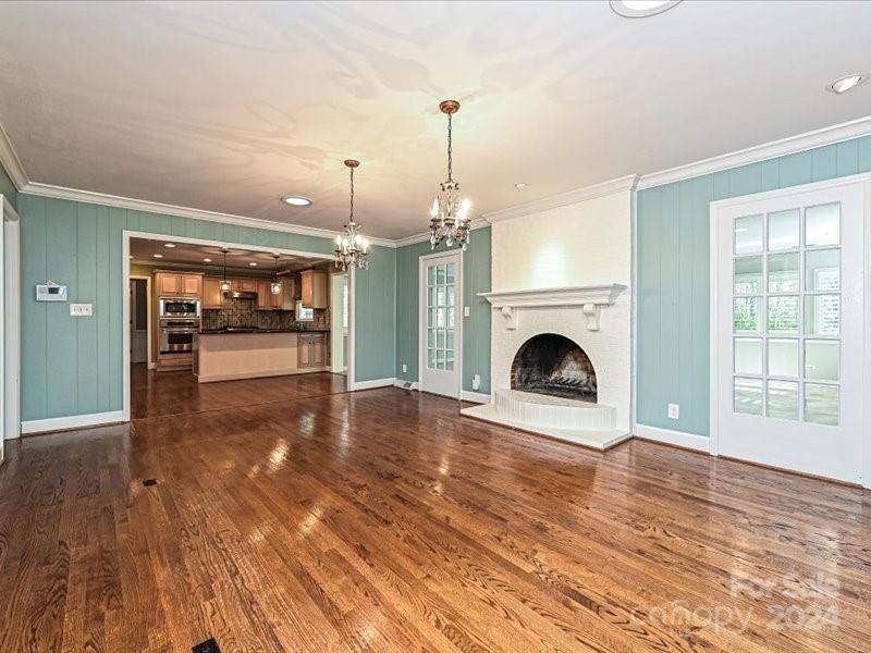 3711 High Ridge Road Charlotte, NC 28270 - Photo 13 of 39 a view of a livingroom with a fireplace a chandelier and wooden floor