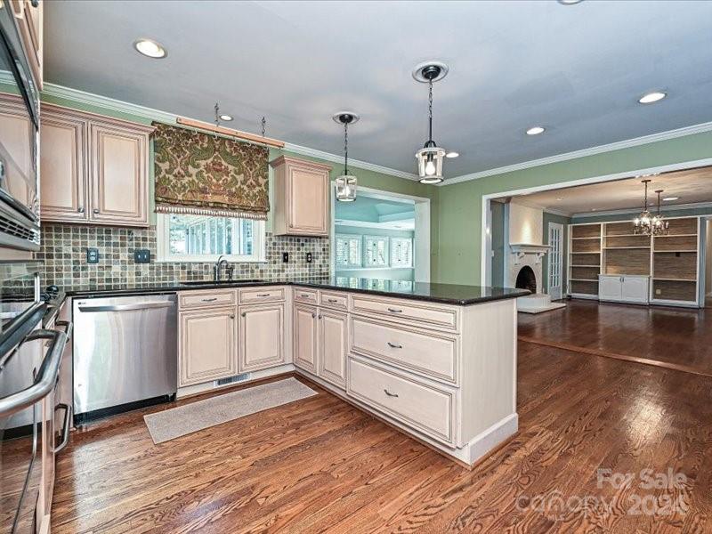 3711 High Ridge Road Charlotte, NC 28270 - Photo 18 of 39 a kitchen with granite countertop a stove a sink and white cabinets with wooden floor