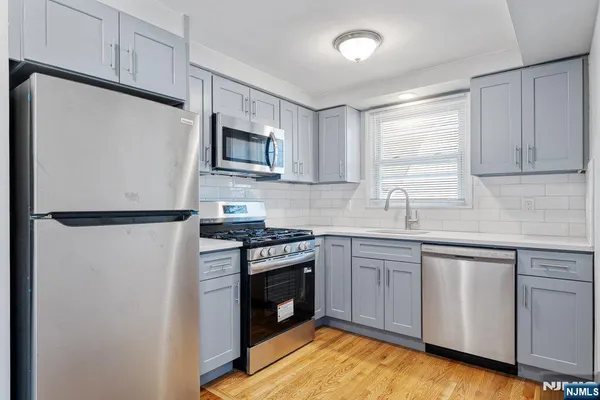 a kitchen with stainless steel appliances a stove sink and microwave