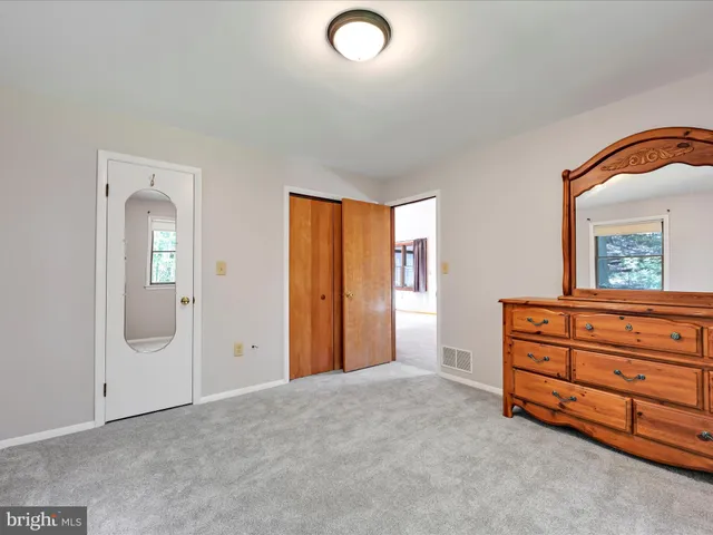 an empty room with window and mirror