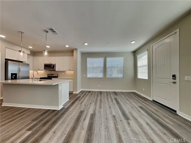 a view of kitchen with wooden floor and electronic appliances
