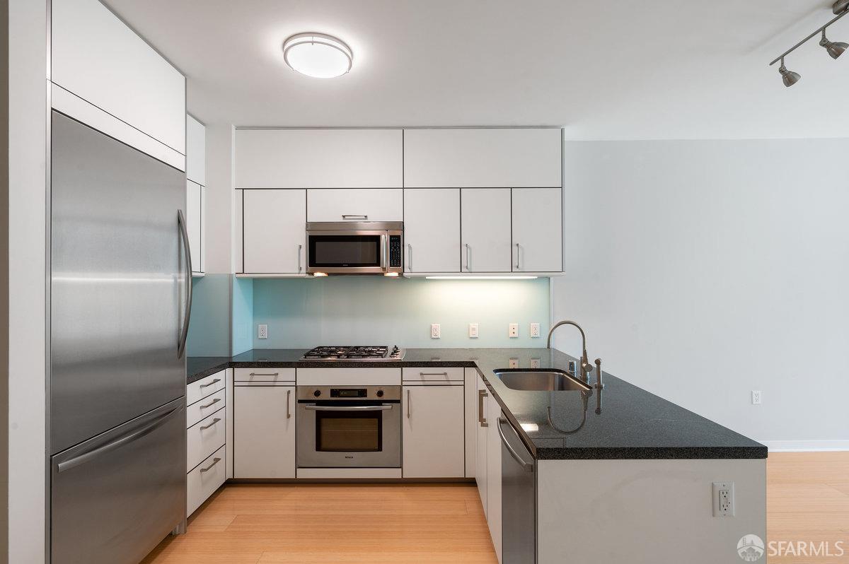 333 Main Street, Unit 4M San Francisco, CA 94105 - Photo 6 of 39 a kitchen with stainless steel appliances granite countertop a sink stove and refrigerator