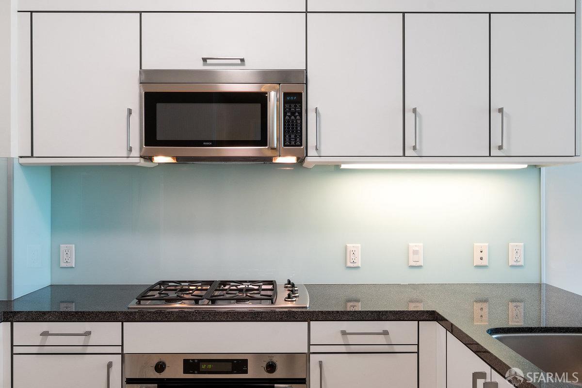 333 Main Street, Unit 4M San Francisco, CA 94105 - Photo 7 of 39 a kitchen with granite countertop white cabinets and stainless steel appliances