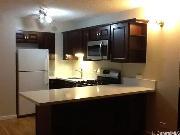 a view of kitchen with stainless steel appliances wooden cabinets and a sink