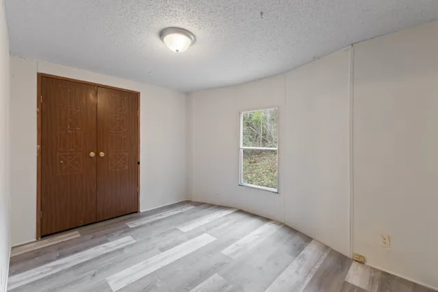 an empty room with windows and closet