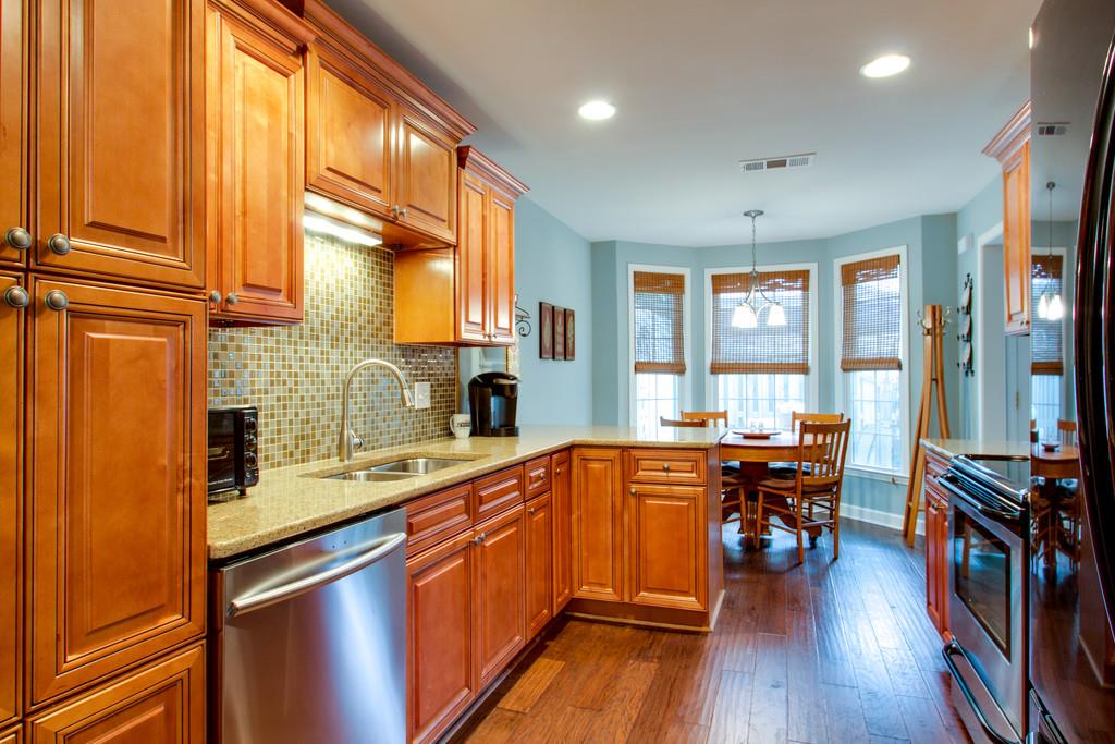 1323 General George Patton Road Nashville, TN 37221 - Photo 14 of 30 a kitchen with stainless steel appliances sink microwave and wooden floor