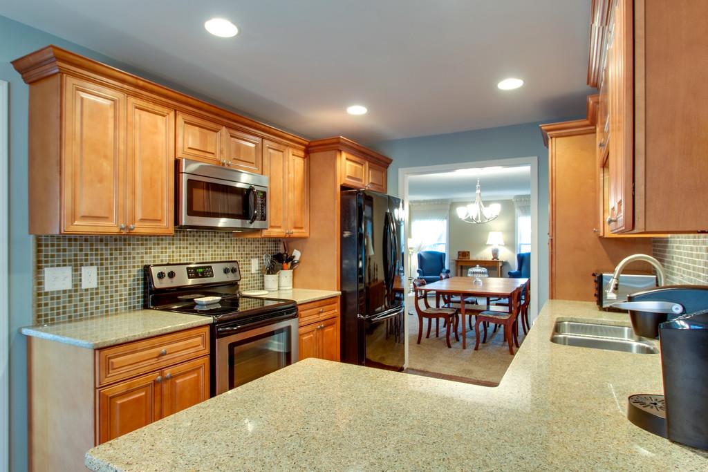 1323 General George Patton Road Nashville, TN 37221 - Photo 17 of 30 a kitchen with stainless steel appliances granite countertop a stove top oven a sink a dining table and chairs