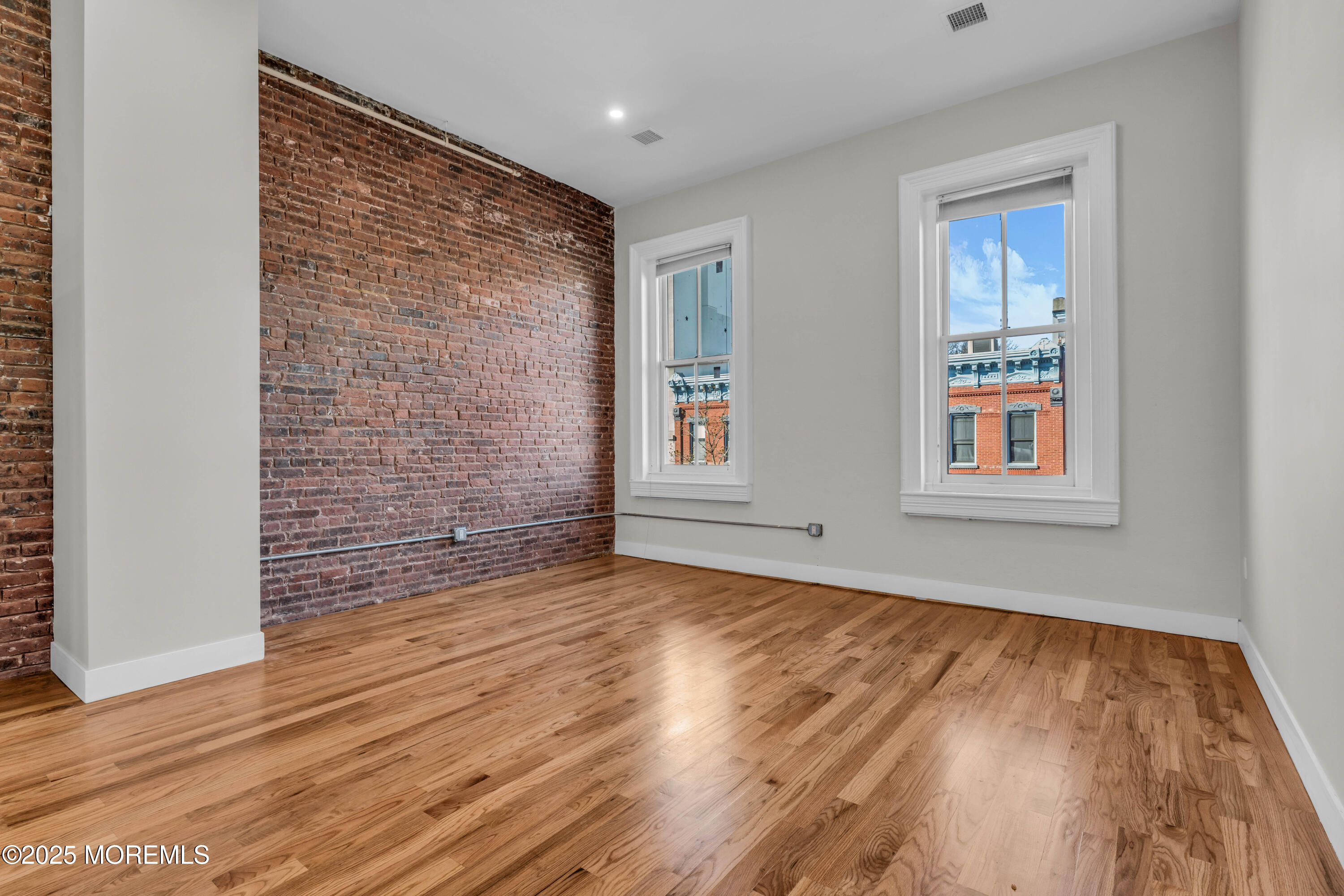 7 Broad Street, Unit 4 Red Bank, NJ 07701 - Photo 2 of 23 a view of an empty room with wooden floor and a window
