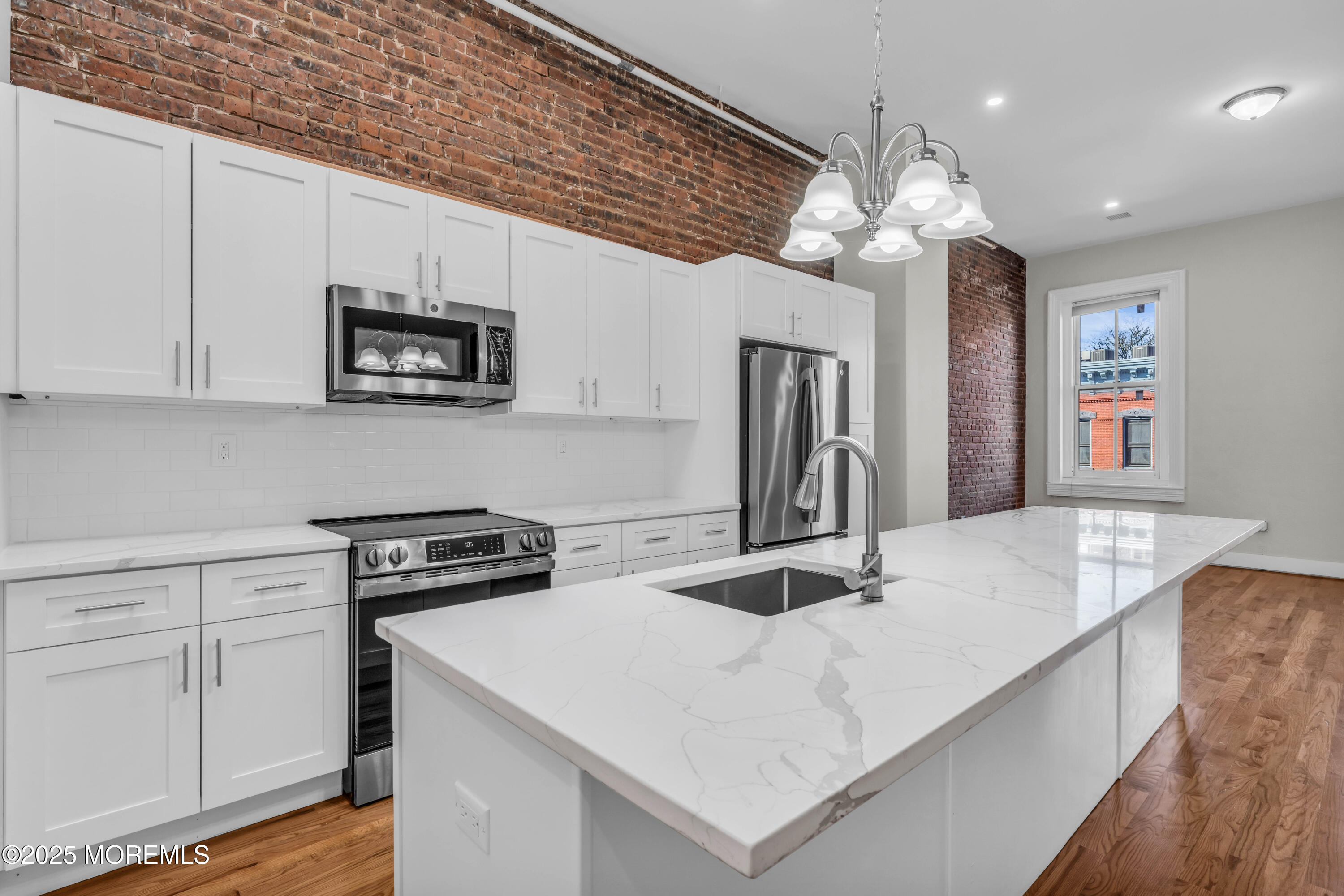7 Broad Street, Unit 4 Red Bank, NJ 07701 - Photo 5 of 23 a kitchen with kitchen island a sink stainless steel appliances and cabinets