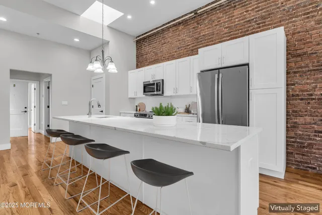 a kitchen with kitchen island stainless steel appliances a sink and a refrigerator