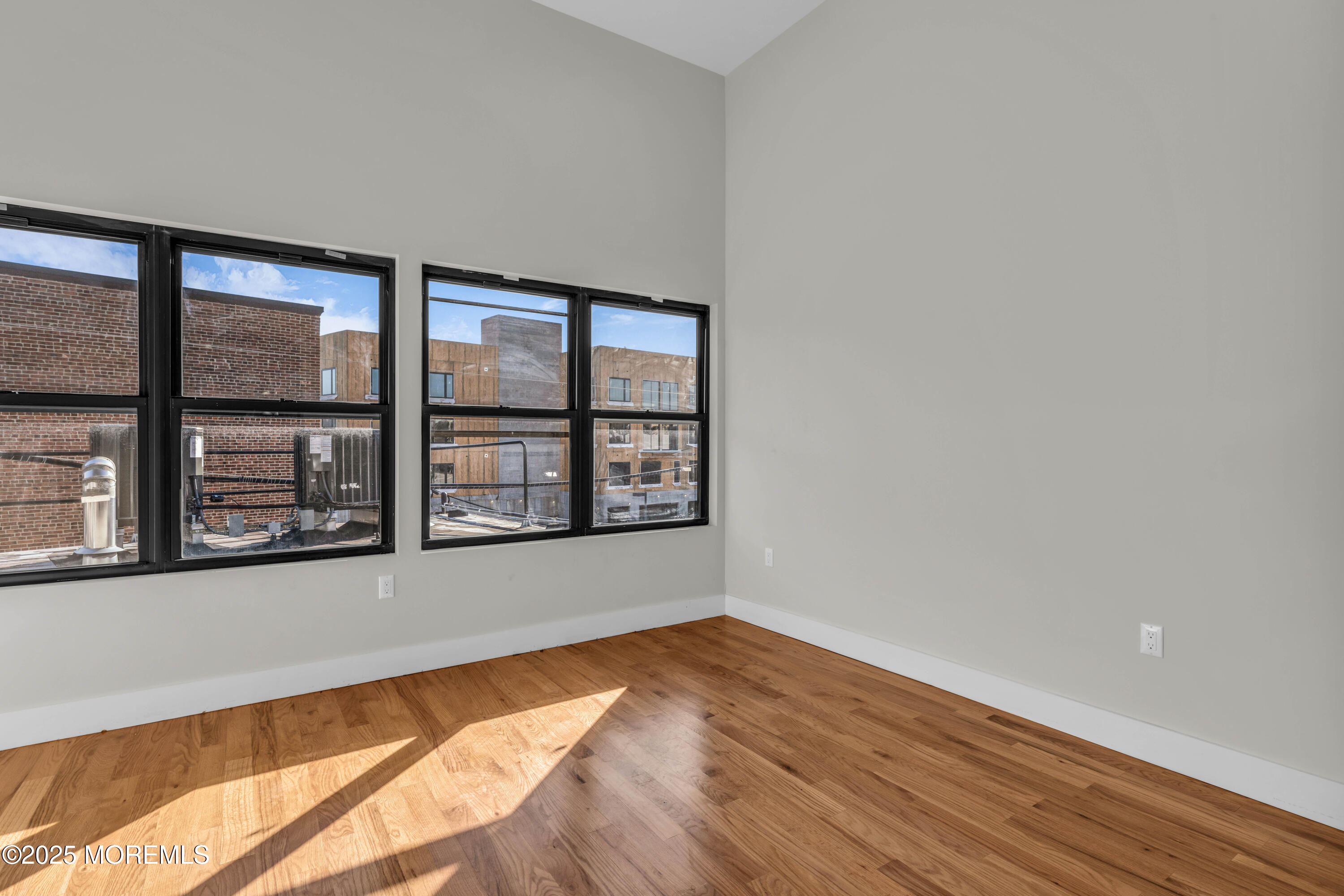 7 Broad Street, Unit 4 Red Bank, NJ 07701 - Photo 10 of 23 an empty room with wooden floor and windows
