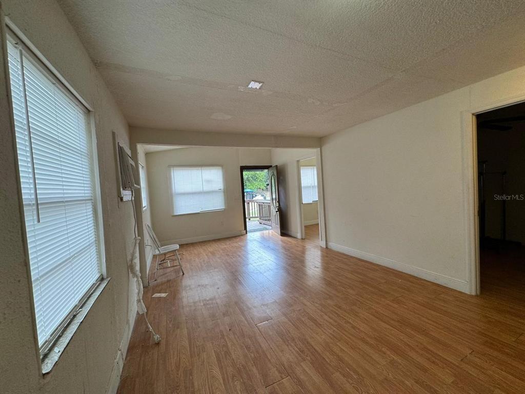 140 East 12th Street Apopka, FL 32703 - Photo 2 of 13 a view of an empty room with wooden floor and a window