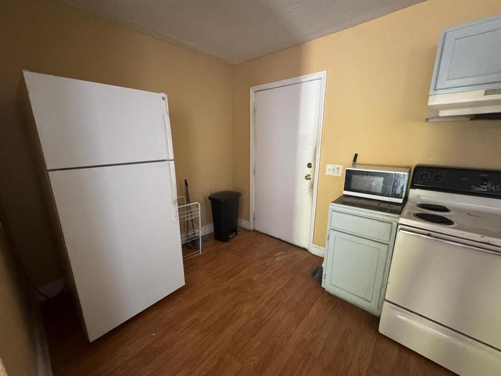 140 East 12th Street Apopka, FL 32703 - Photo 5 of 13 a view of kitchen with wooden floor and electronic appliances