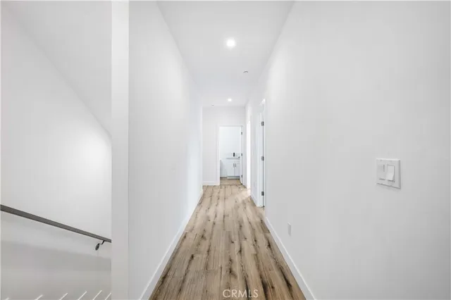a view of a hallway with wooden floor and closet
