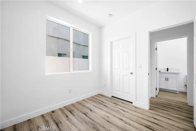 a view of a room with wooden floor and a bathroom