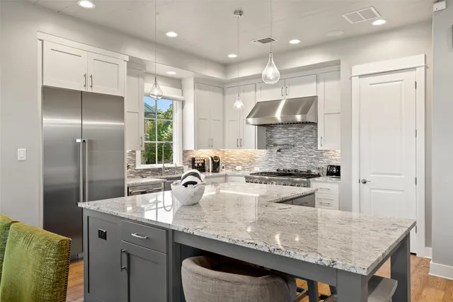 a kitchen with a stove and a flat screen tv
