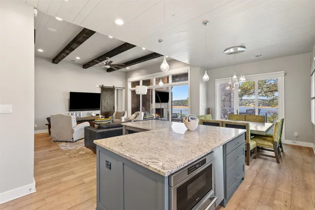 a kitchen with granite countertop kitchen island stainless steel appliances a sink stove and refrigerator